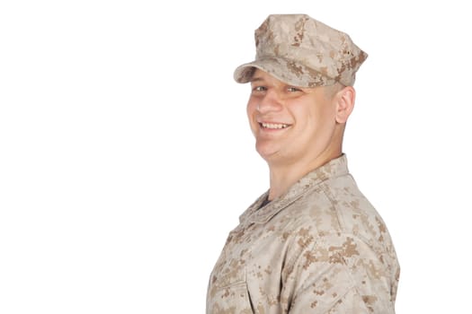 Shoulder studio portrait of smiling United States army soldier, marine infantry or military contractor in camouflage combat uniform and patrol cap