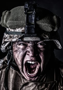 Close up portrait of aggressive screaming army soldier, attacking with mad yelling commando, roaring and grimacing marine in camouflage helmet with sweaty, dirty face studio shoot on black background