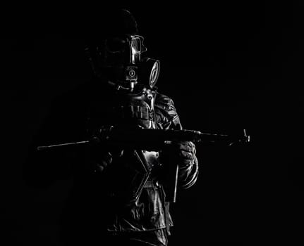 Futuristic nazi soldier gas mask and steel helmet with schmeisser handgun black background studio shot