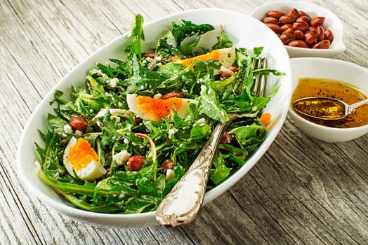 Fresh healthy dandelion salad with eggs overhead shoot