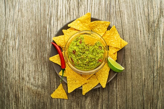 Guacamole sauce with corn nachos chips on plate