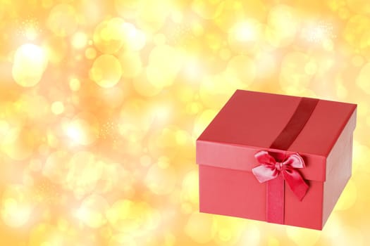 Red christmas gift box on blur golden abstract bokeh background. Beautiful texture. Space for your design. Card concept.