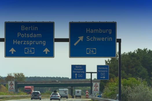German motorway sign with inscription in German direction arrow to the cities - Berlin, Potsdam, Herzsprung, Hamburg and Schwerin
