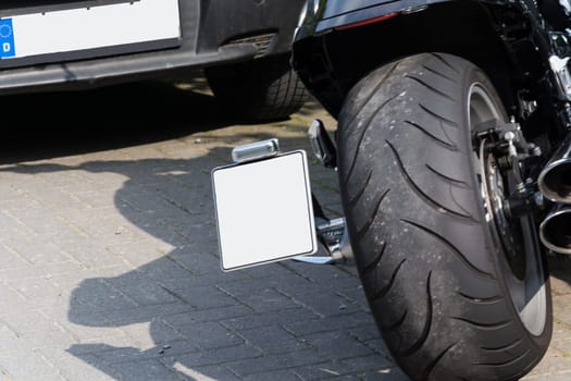 Close up of a large tire of a modern motorcycle parked.