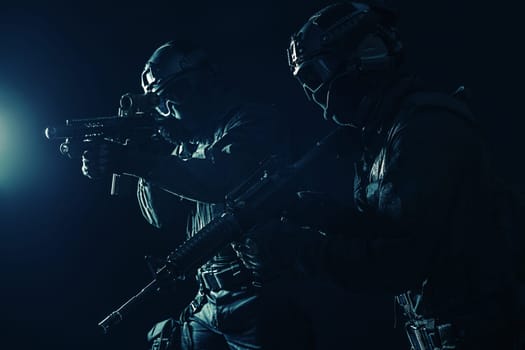 Spec ops police officers SWAT in black uniform and face mask studio shot