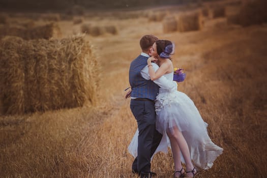 bride and groom near hay barn