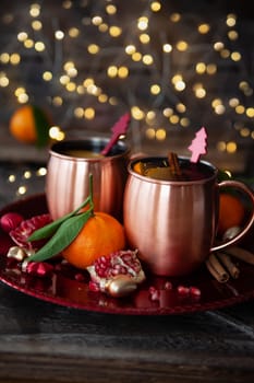 Two mugs of mulled wine with cinnamon and pomegranate