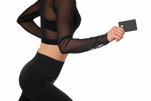athletic fitness woman in sport wear holding black premium credit bank card on white background. payment online