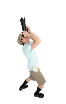 Silly man tourist in blue shirt, black sandals and hat holding big dslr camera and shooting. Traveler concentrating and making pictures. Isolated on white background.