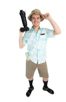Happy man tourist in blue shirt, brown shorts and hat holds dslr camera. Traveler smiles and going to photo tour. Isolated on white background. Interesting trip on summer vacation.