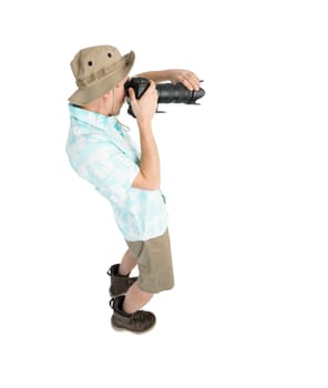 Silly man tourist in blue shirt, brown shorts and hat holding big dslr camera and shooting. Traveler concentrating and making pictures. Isolated on white background.