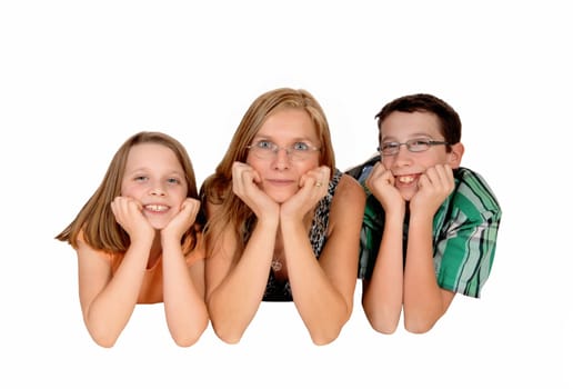 A mother with her two kids lying on the stomach on the floor and there .faces in there hands, isolated for white background..