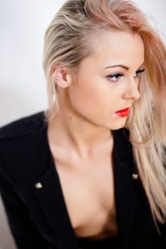beautiful blonde young sexy woman posing on black dress and nude skin seriously
