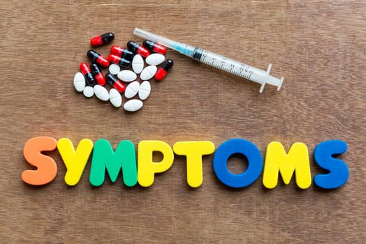 symptoms colorful word in the wooden background