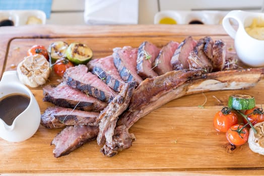 Grilled tomahawk steak on wooden plate