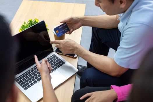 Young freelance group using credit card for paying in cafe. Close up