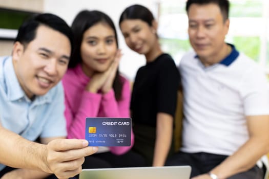 Young freelance group using credit card for paying in cafe. Selective focus on credit card