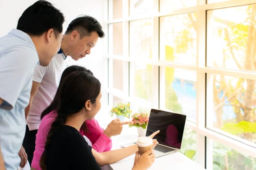 group of Freelance point finger to laptop while thier working in cafe