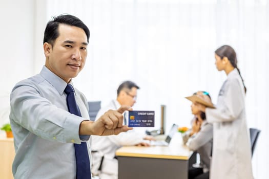 Portrait of Young adult Patient with credit card with examination room medical office background for insurance concept