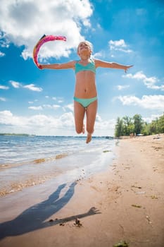 Little girl jumping high in water of a sea
