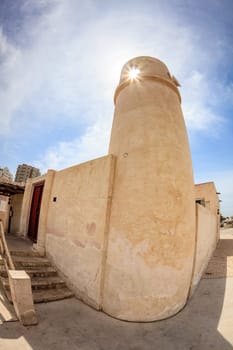 Sun shining through an opening in mnaret tower of a mosque in Fujeirah, UAE
