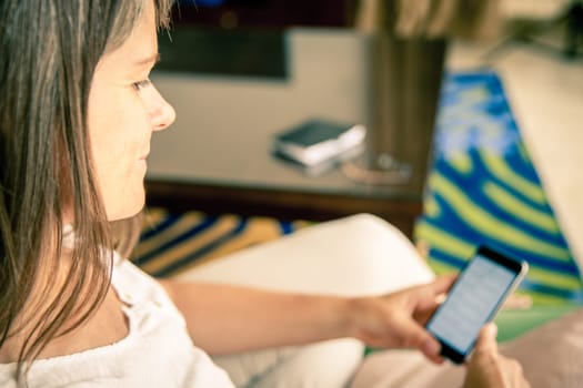Mature woman is checking messages on her cell phone