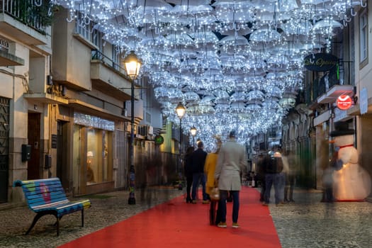 AGUEDA, PORTUGAL - CIRCA DECEMBER 2018: The beauty of white umbrellas iluminated by Christmas lights decorating the streets of Agueda Portugal