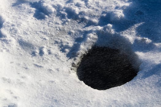 Ice Fishing Hole Being Drifted Over by Snow.