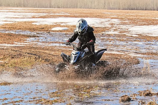 Child creating a large splash with his quad.