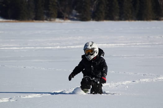 Child Wearing an OHV Stepping Through Deep Snow.