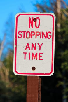 A red no stopping any time sign.