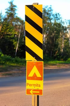 A permits sign with an arrow at a campground.