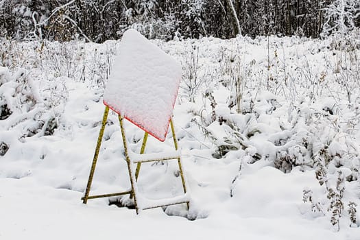 Construction sign hidden by sudden snow storm.