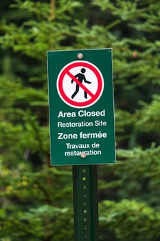 A green sign indicating area closed as a restoration site.