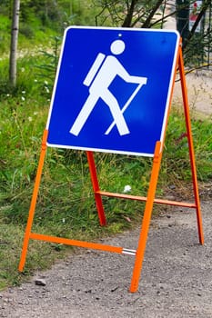 A temporary blue hiking sign for a trail.