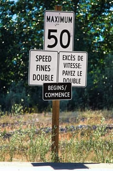A Speed Fines Double Begins sign along a highway.
