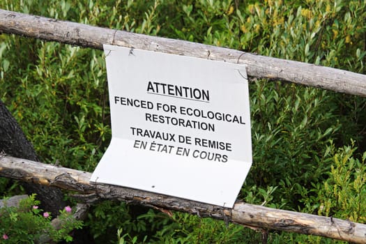 Attention fenced are for ecological restoration sign.