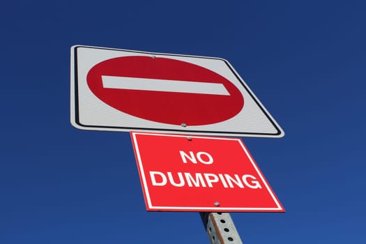 No Entry or Dumping Sign Against Blue Sky.