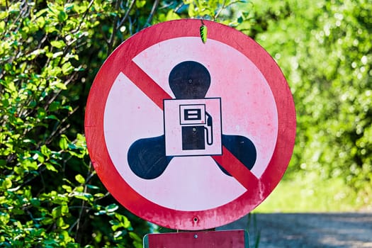 A no gas motors sign at lake with a small hook hanging.