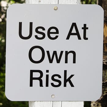 Closeup of a use at own risk sign.