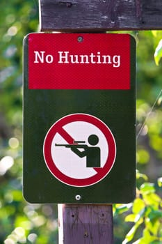 Closeup of a no hunting sign on a green background.