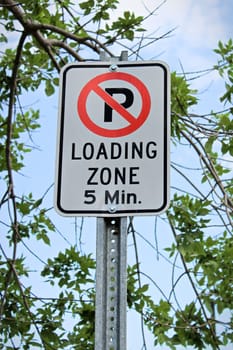 A no parking, five minute loading zone sign.