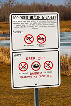 Warning signs around storm drainage pond.
