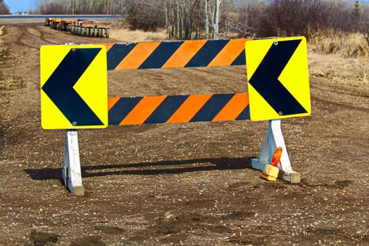 Detour construction barricade along a gravel road.