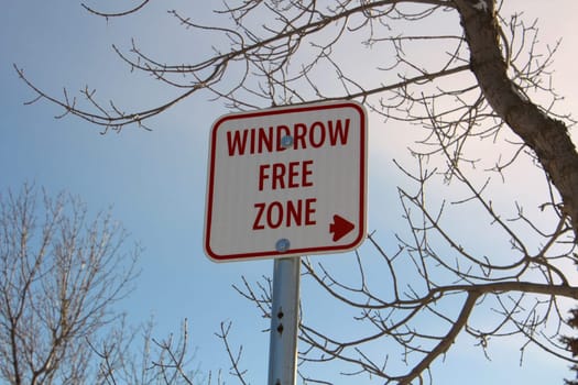 Windrow Free Zone Sign Against Blue Sky.