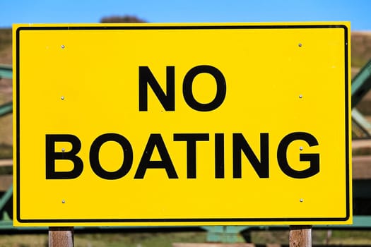 Closeup of a yellow no boating sign.