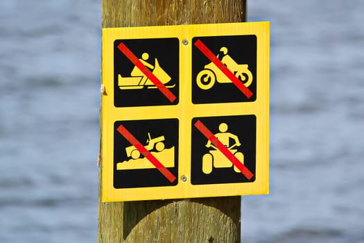 No off-road vehicle sign posted near water.