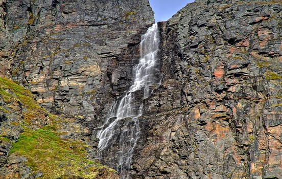 Snow melting water falling from the top of Norwegian fjord.
