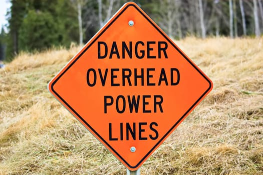 Closeup of a danger overhead power line sign.