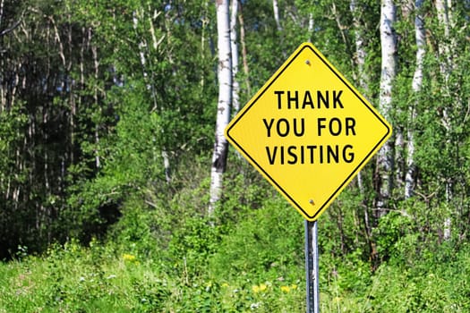 A thank you for visiting sign against a forest background.